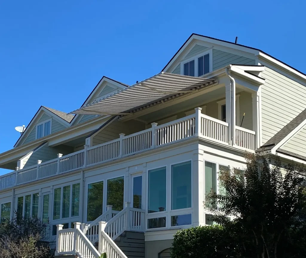SunSetter retractable awning on a Patriot Blinds & More client's home, featuring white and beige stripes matched to the home exterior.